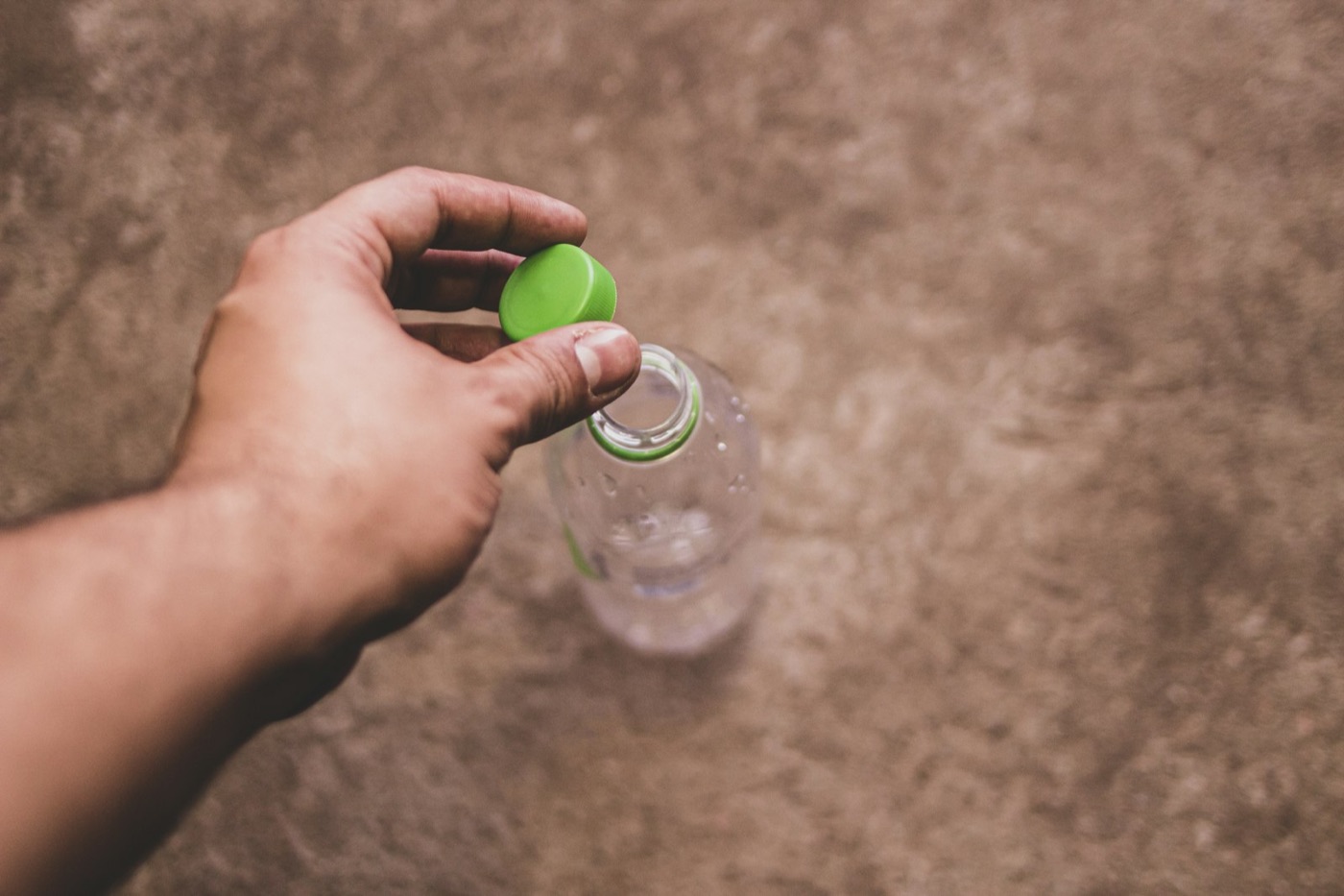 A hand holding a plastic bottle