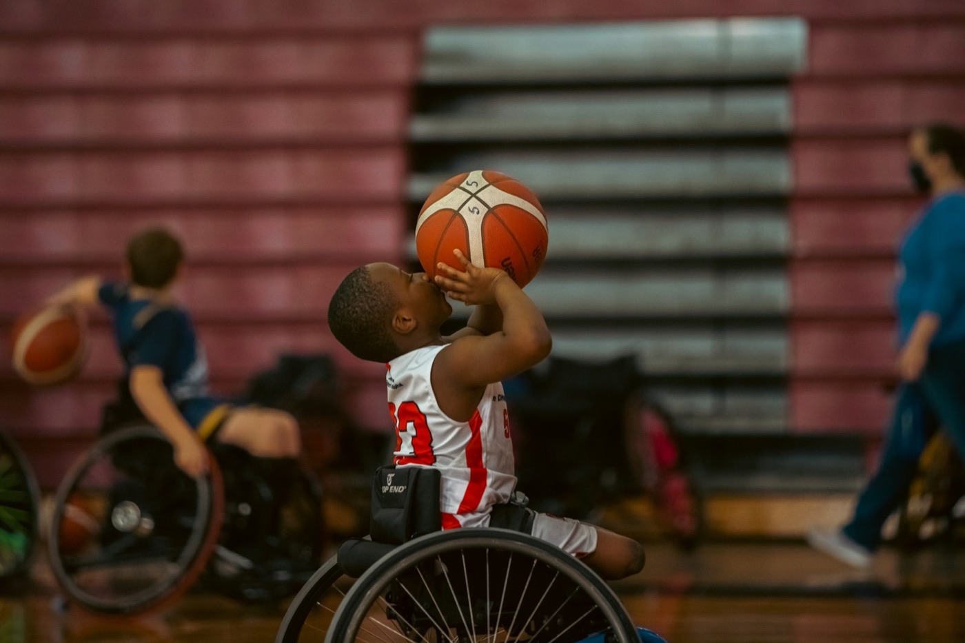 A young wheelchair basketball player taking a shot